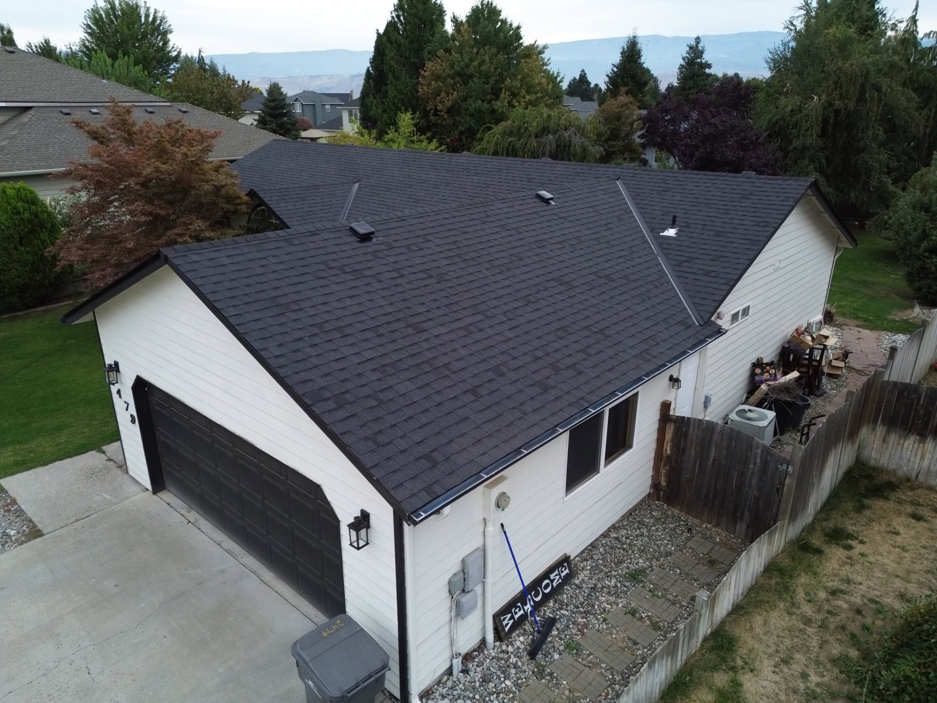 Finished black shingle roof on a white house