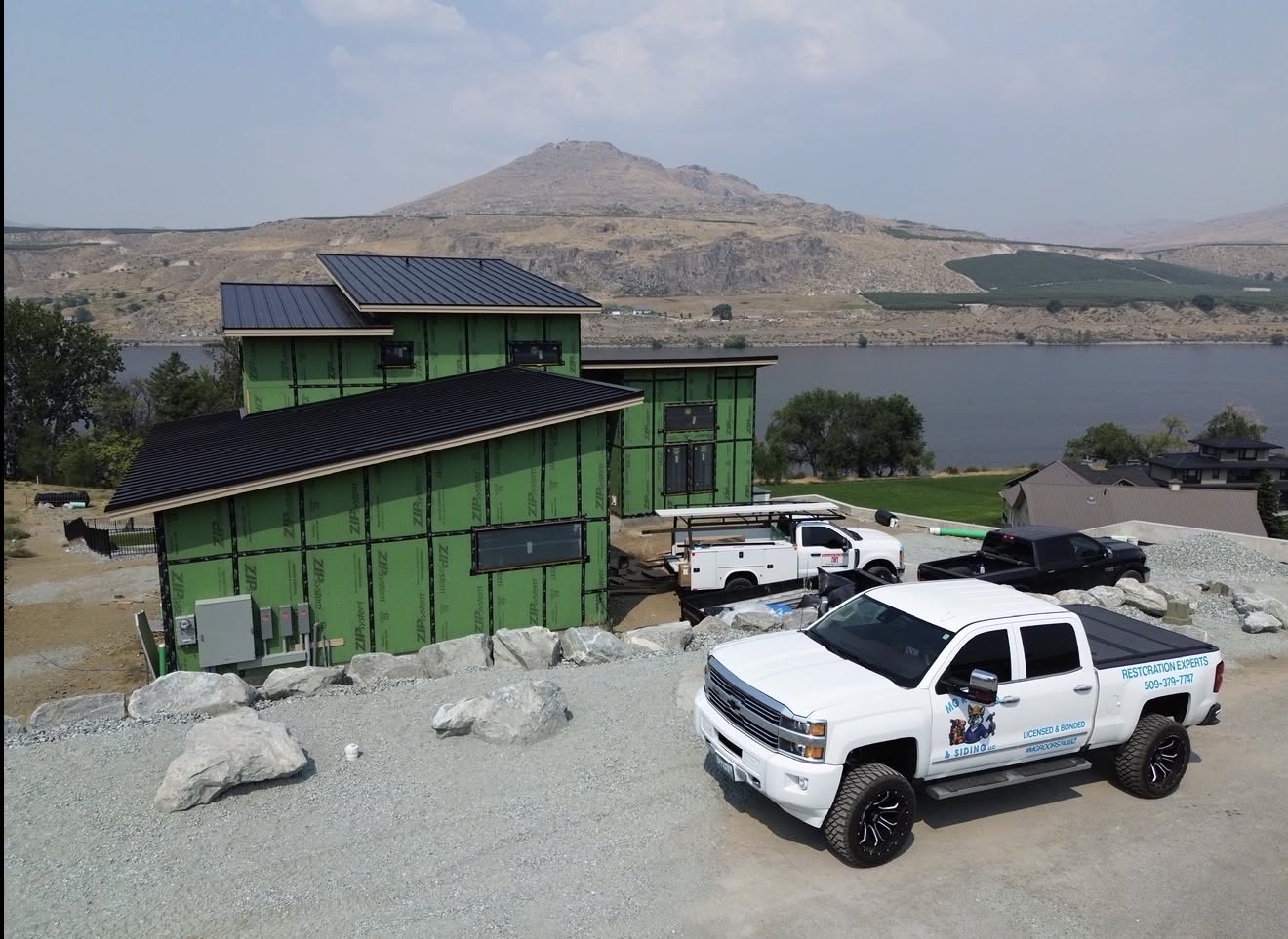 MG Roofing truck at a metal roofing project near the Columbia River