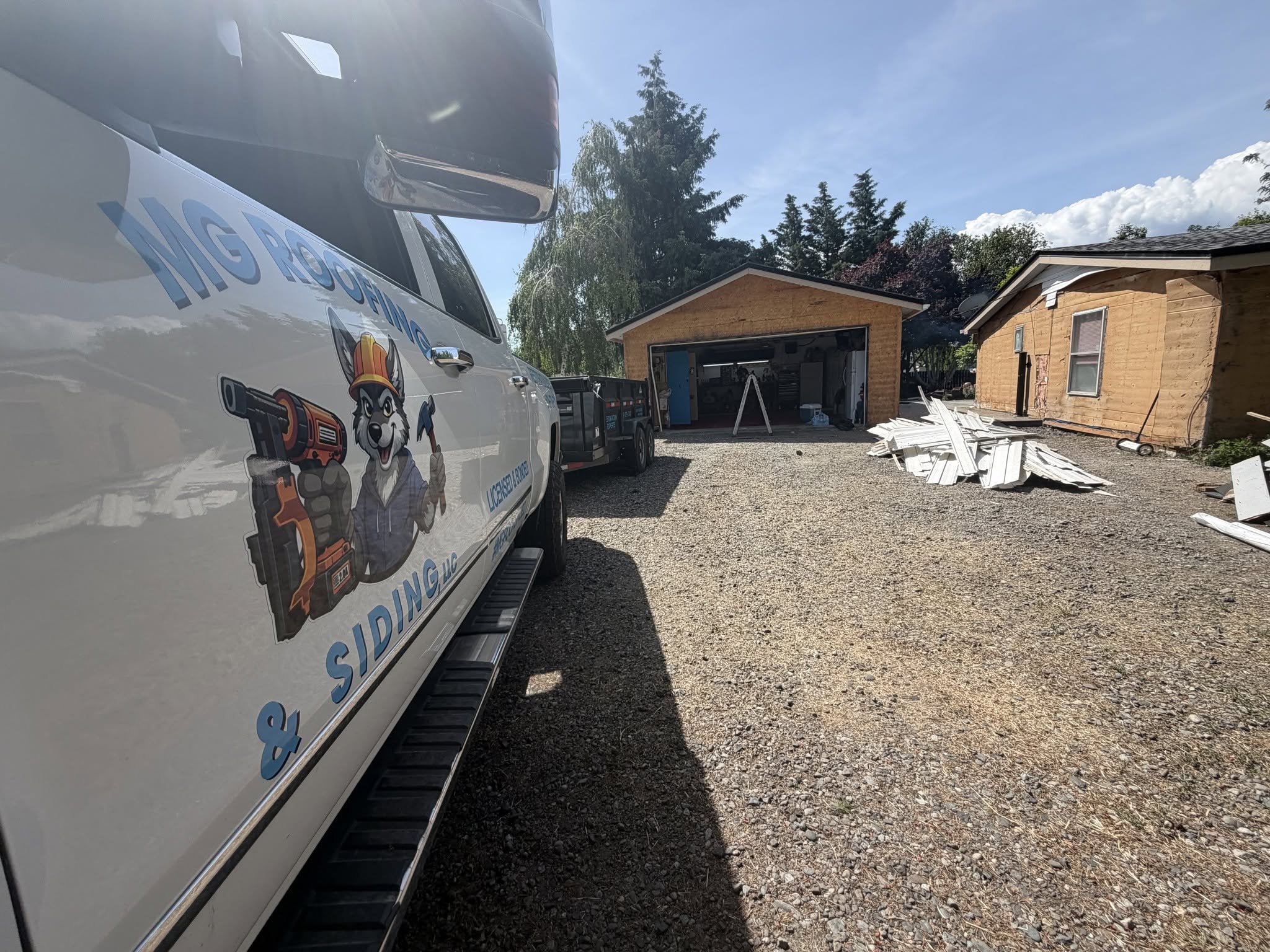 MG Roofing and Siding work truck with wolf mascot at a local jobsite
